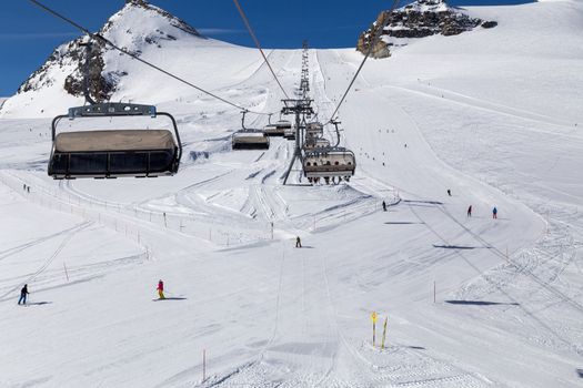 Zermatt, Switzerland - April 13, 2017: People skiing on a ski piste under a lift