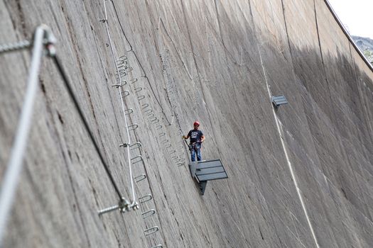 Finkenberg, Austria - June 9, 2018: An alpinist climbing the Via Ferrata on the Schlegeis Dam