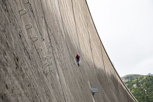 Finkenberg, Austria - June 9, 2018: An alpinist climbing the Via Ferrata on the Schlegeis Dam