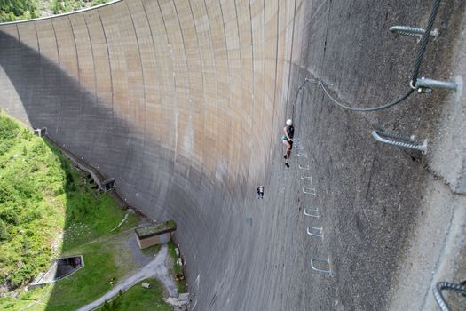 Finkenberg, Austria - June 9, 2018: Group of alpinists climbing the Via Ferrata on the Schlegeis Dam