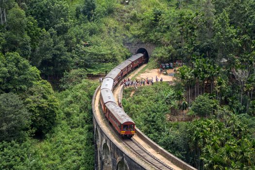 Demodara, Sri Lanka - August 4, 2018: A red train crossing the famous Nine Arch Bridge