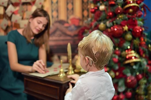 A Boy with Cochlear Implants Seal Letter To Santa Claus For New Year