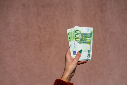 Hand holding and showing euro money or giving money. World money concept, 100 EURO banknotes EUR currency isolated. Concept of rich business people, saving or spending money.