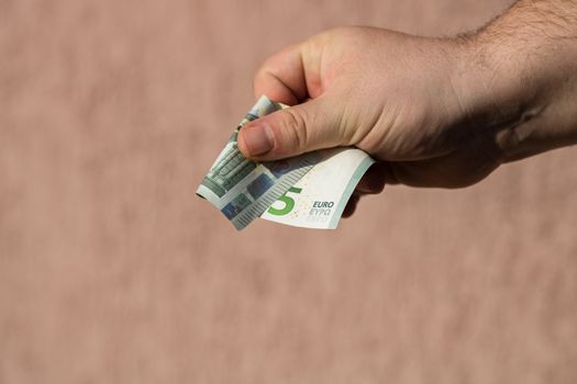 Man hands giving money like a bribe or tips. Holding EURO banknotes on a blurred background, EU currency