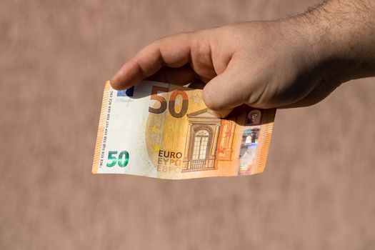 Man hands giving money like a bribe or tips. Holding EURO banknotes on a blurred background, EU currency