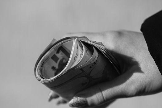 Hand holding rolled money, holding euro banknotes on a blurred background, EURO currency .