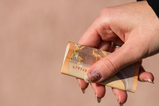 woman hands giving money like a bribe or tips. Holding EURO banknotes on a blurred background, EU currency