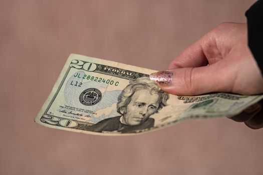 Hand holding or giving dollars money. Holding US dollars banknote on a blurred background, US currency