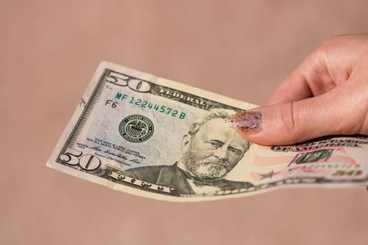 Hands giving money like a bribe or tips. Holding US dollars banknotes on a blurred background, US currency