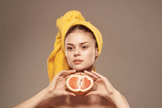 Beautiful woman with a towel on her head bared shoulders grapefruit Skin care. High quality photo