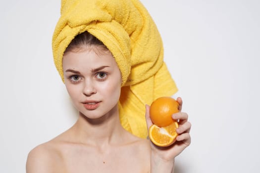 Cheerful woman with bared shoulders oranges in the hands of citrus skin care vitamins health. High quality photo