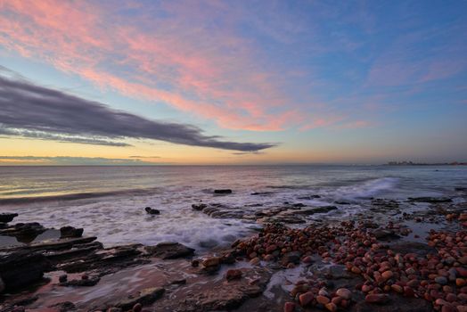 Several rocks on the beach in the warm light of a sunrise