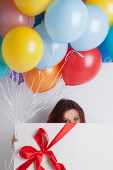 Young woman with balloons and big gift box