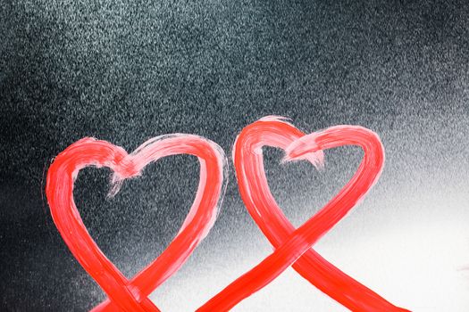 Two abstract red painted hearts on metal background