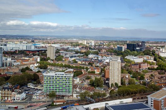 Aerial view across the tower blocks and offices of Portsmouth City Centre on a sunny day in Hampshire.  Portsmouth Harbour railway station is towards the bottom with the Royal Navy Dockyard to the left of centre.