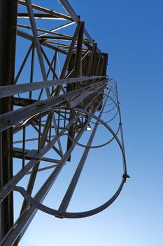 Low angle perspective view of a guarded ladder on galvanized steel frame water tower, Burgersfort, South Africa