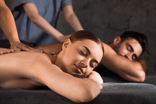 Beautiful couple relaxing together at spa centre at beauty treatment massage