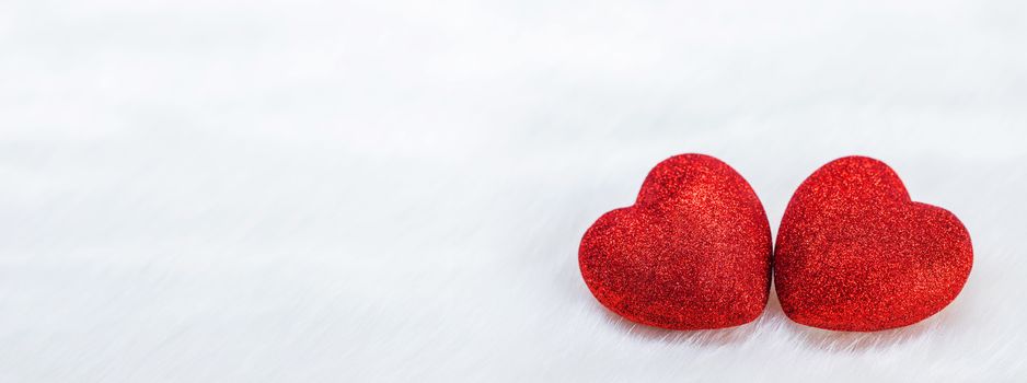 Two red glitter hearts symbol of love on white fur background, Saint Valentine Day celebration