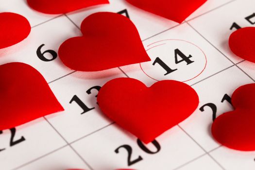 Valentine's day red silk hearts on calendar with 14 february date background, love, celebration concept