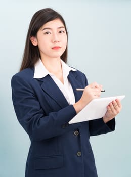 Asian teenage girl in suit using computer digital tablet isolate on blue background