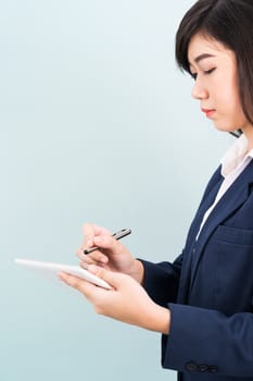 Asian teenage girl in suit using computer digital tablet isolate on blue background