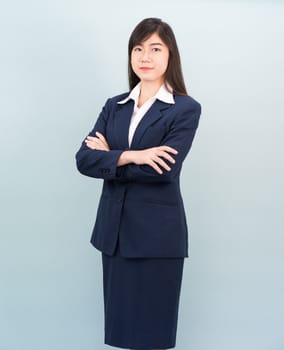 Teenage girl long hair is standing with her arms crossed wearing suit and white shirt on blue background