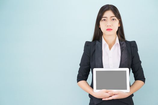 Young women in suit holding her digital tablet standing against blue background