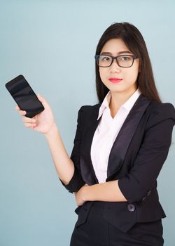 Young women in suit holding her smartphone standing against blue background