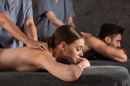 Beautiful couple relaxing together at spa centre at beauty treatment massage
