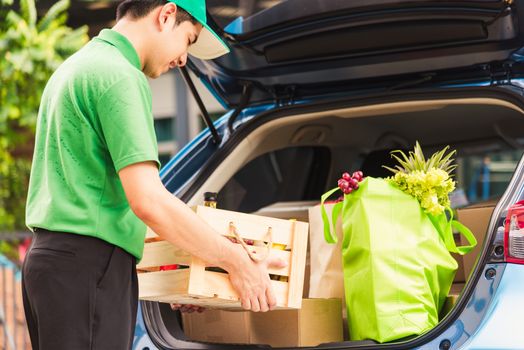 Asian delivery man grocery prepare service giving fresh vegetables food and fruit full in wooden basket on back car to send woman customer at door home after pandemic coronavirus, Back to new normal