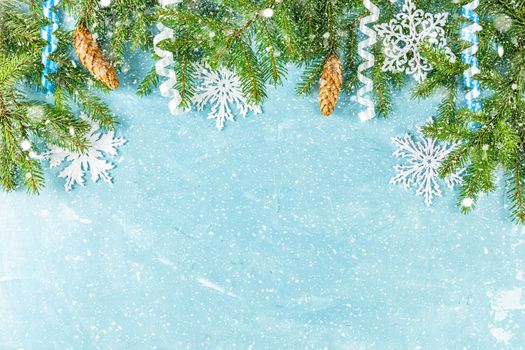 Christmas or New Year background with green fir branches and cones on blue background. Winter concept, top view, copy space