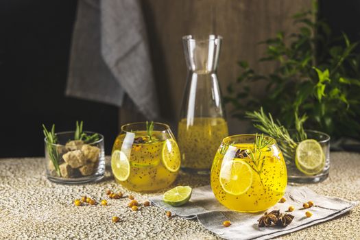 Sea buckthorn iced tea or lemonade with lime, rosemary, star anise and chia seeds. Tropical refreshing cold drink for summer