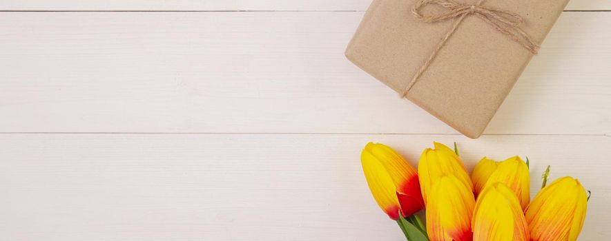 Beautiful tulip flower and gift box on wooden background with romantic, presents for mother day with pastel tone, spring or summer nature for decoration on desk, holiday concept, banner website.