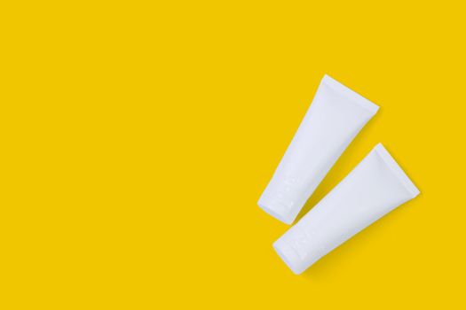 Cosmetic tube isolated on yellow background, mockup package of lotion or cream, product beauty and makeup, treatment skin care or acne, packaging or container, health and medicine template.