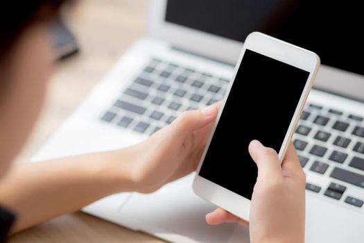 Mockup young businesswoman using smart mobile phone and laptop computer with screen blank on desk, asian woman use device internet for working, business and education concept, back view.