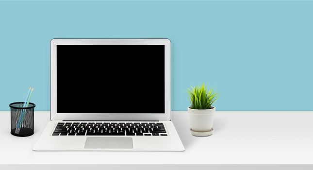 Mockup laptop computer display blank screen on desk in office, workspace with mock up computer screen empty and keyboard, mouse, plant and copy space on table in home, business presentation concept.