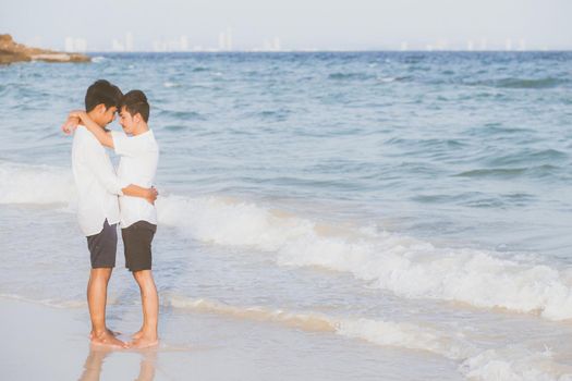 Homosexual portrait young asian couple standing hug together on beach in summer, asia gay going tourism for leisure and relax with romantic and happy in vacation at sea, LGBT legal concept.