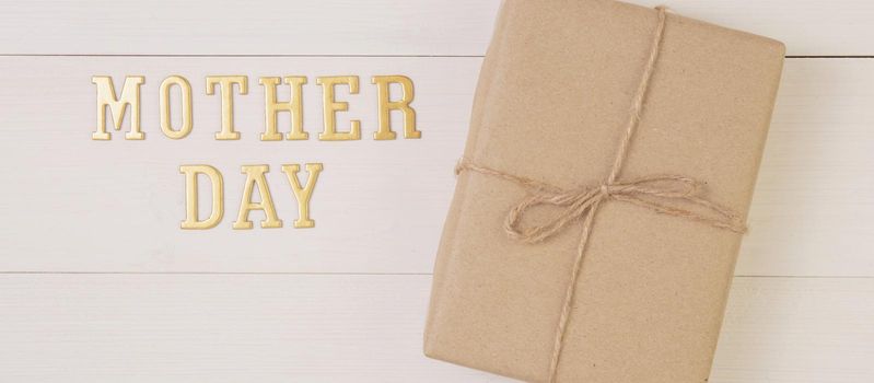 Gift box and text is mother day on wooden background with romantic, presents word and message, package with congratulation with happy, nature on desk, holiday concept, banner website.