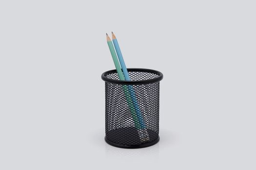 Pencil in metal mesh pot isolated on white background, stationery and equipment for education.