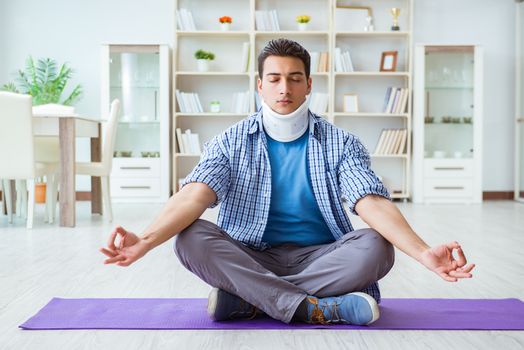 Man with neck injury meditating at home on floor