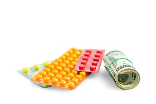 Rolled up banknotes next to medications. Treatment cost. Medical business. Pharmaceutical business. Objects isolated on white with shadow.