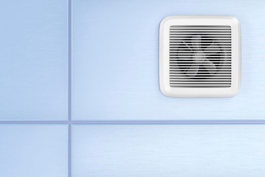 Exhaust fan mounted on the blue tiles in the bathroom