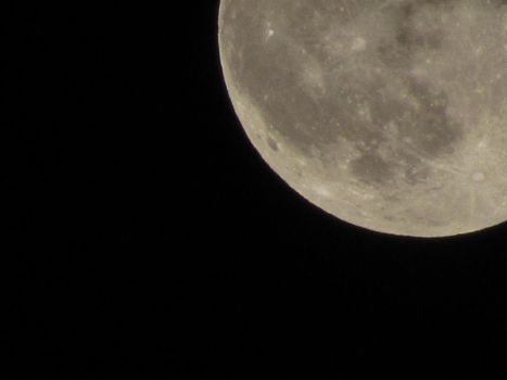 The Moon close-up on a black night sky shot through a telephoto camera.