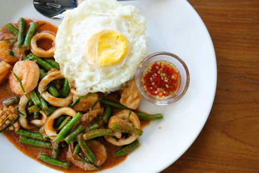 shrimp squid stir fried with cow pea & spicy sauce serving with rice & fried egg