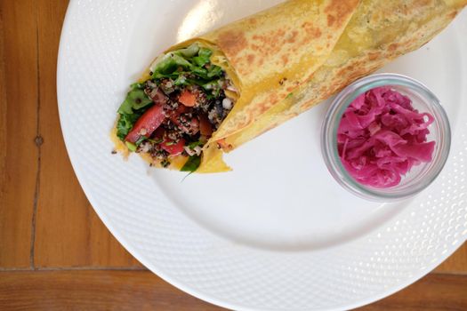 vegan wrap with quinoa, black bean, mango, cashew nut, bell pepper