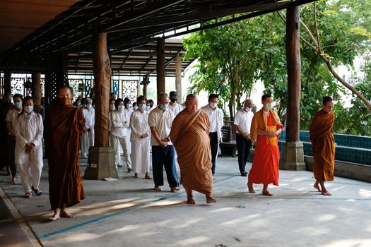 Chiang Mai, Thailand -  November 18, 2020: buddhist monk and people walking for mindfulness meditation at Khumphucome hotel in Chiang Mai, Thailand on November 18, 2020