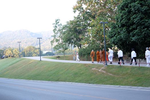 Chiang Mai, Thailand -  November 19, 2020: buddhist monk and people walking for mindfulness meditation at Chiang Mai university in Chiang Mai, Thailand on November 19, 2020