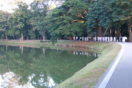 Chiang Mai, Thailand -  November 19, 2020: buddhist monk and people walking for mindfulness meditation at Chiang Mai university in Chiang Mai, Thailand on November 19, 2020