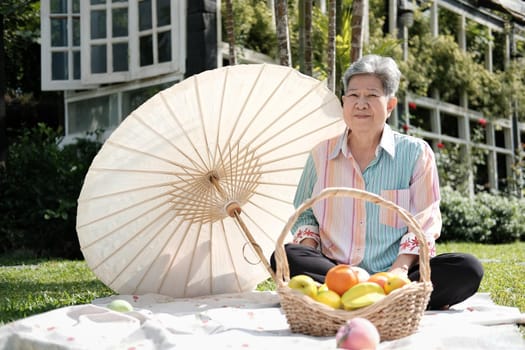 old asian elderly senior elder woman having picnic in garden.