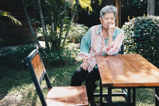 elder woman resting in garden. elderly female relaxing outdoors. senior leisure lifestyle